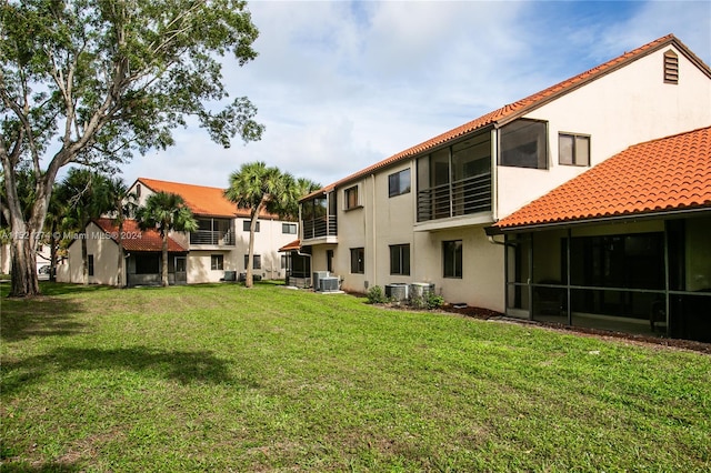 view of yard featuring central air condition unit and a sunroom