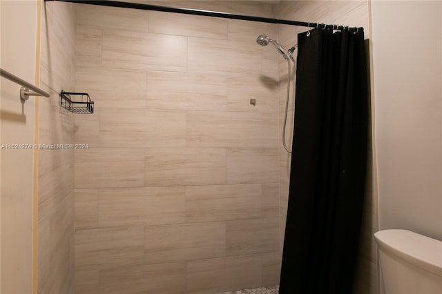 bathroom featuring a shower with curtain and toilet