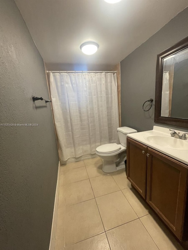 bathroom featuring toilet, tile flooring, and vanity