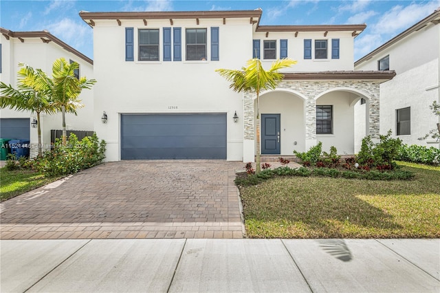 mediterranean / spanish-style house featuring a garage and a front yard