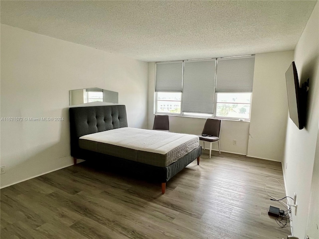 bedroom featuring a textured ceiling and hardwood / wood-style flooring