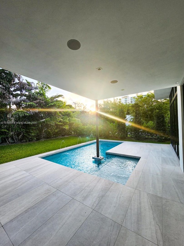 view of pool with a lawn and a patio area