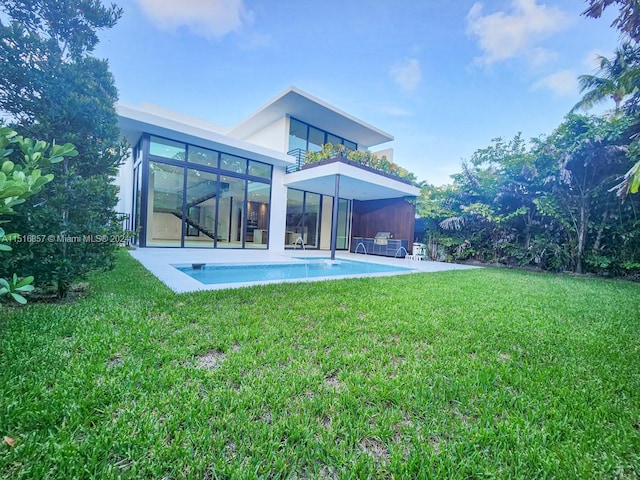 back of property with a yard and a sunroom