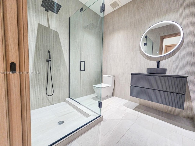 bathroom with tile patterned floors, a shower with shower door, vanity, and toilet