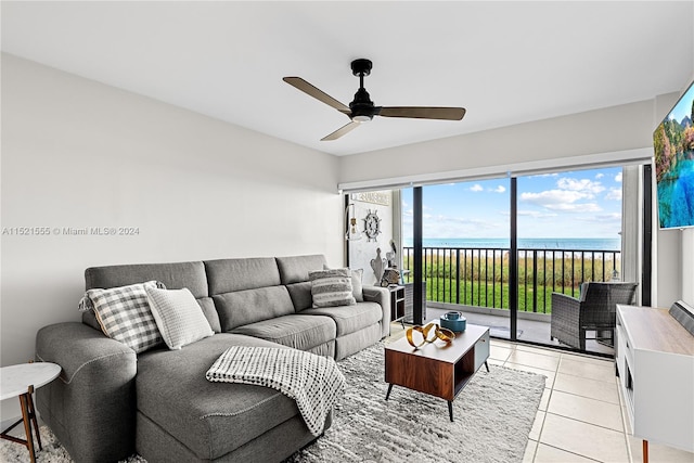 living room with a water view, light tile floors, and ceiling fan