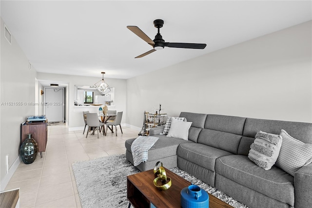 tiled living room featuring ceiling fan with notable chandelier