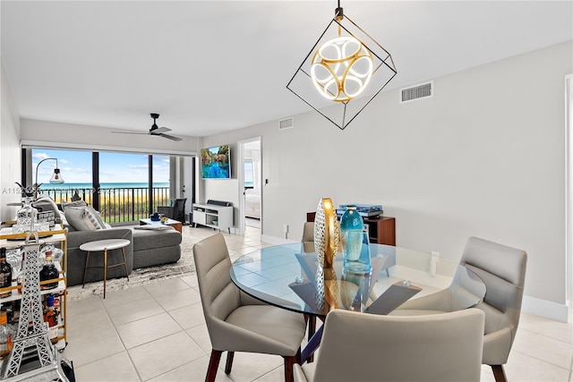 dining space featuring light tile floors and ceiling fan with notable chandelier