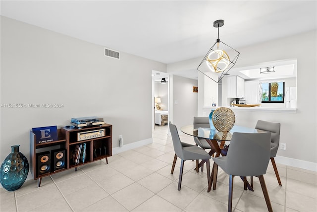 dining space with a notable chandelier and light tile floors