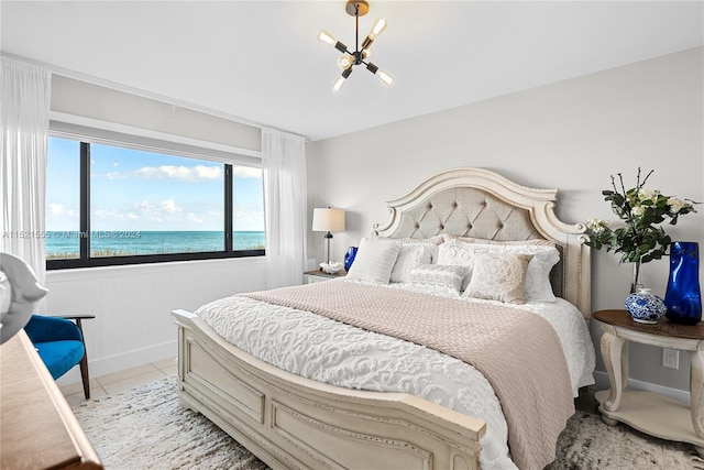 tiled bedroom with an inviting chandelier and a water view