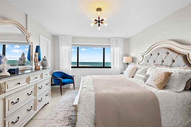 bedroom featuring a notable chandelier, light tile flooring, and a water view