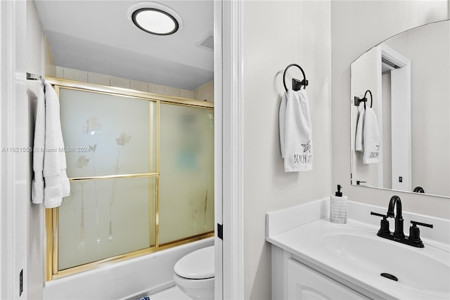 full bathroom featuring vanity, shower / bath combination with glass door, and toilet