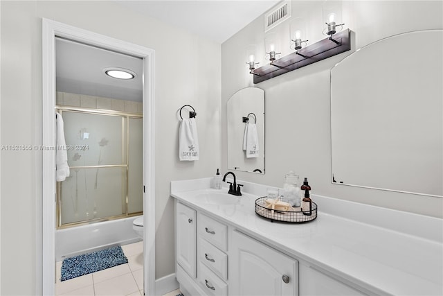 full bathroom with combined bath / shower with glass door, tile floors, large vanity, and toilet