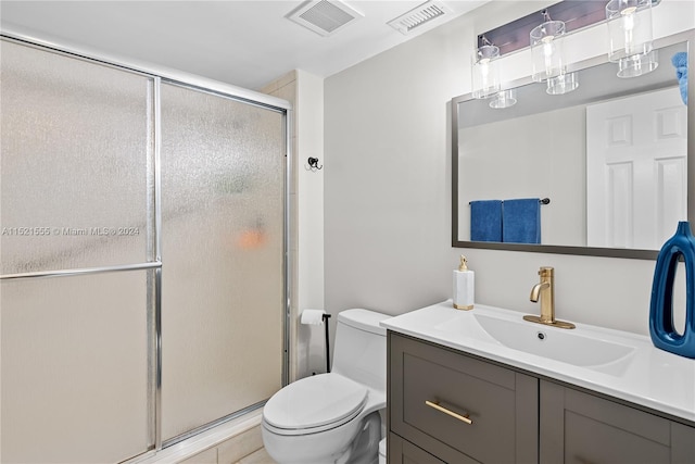 bathroom with toilet, a shower with door, and vanity