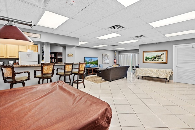 tiled dining room featuring a drop ceiling