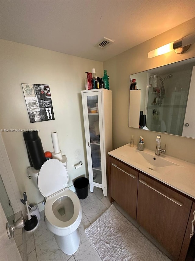 bathroom featuring walk in shower, tile floors, large vanity, and toilet