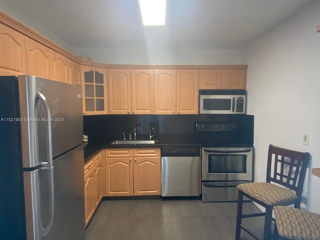 kitchen featuring dark hardwood / wood-style floors, light brown cabinetry, sink, and stainless steel appliances