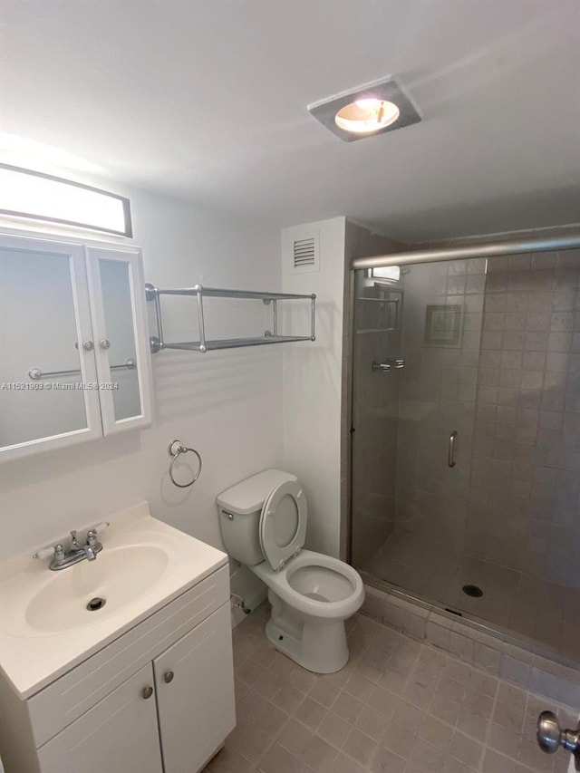 bathroom with toilet, tile flooring, walk in shower, and vanity