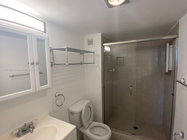 bathroom with walk in shower, toilet, and vanity