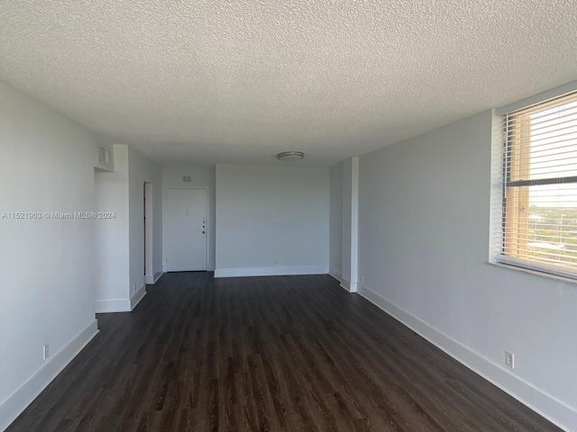 unfurnished room featuring a textured ceiling and dark wood-type flooring