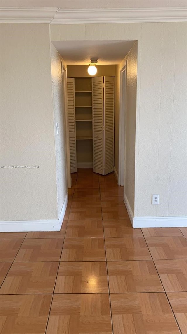 hallway with crown molding and light parquet flooring