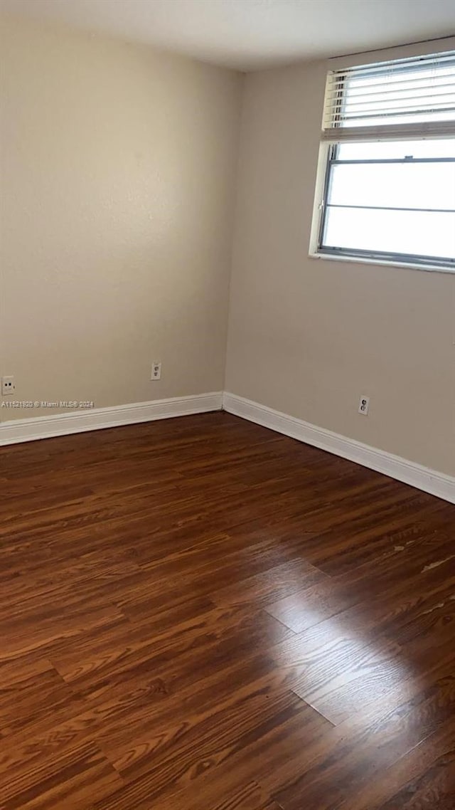 spare room featuring dark wood-type flooring