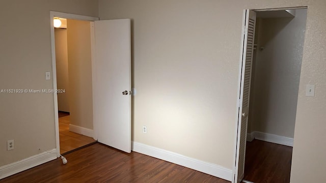 unfurnished bedroom with dark wood-type flooring