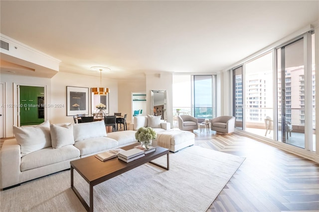 living room with light parquet floors, crown molding, and expansive windows