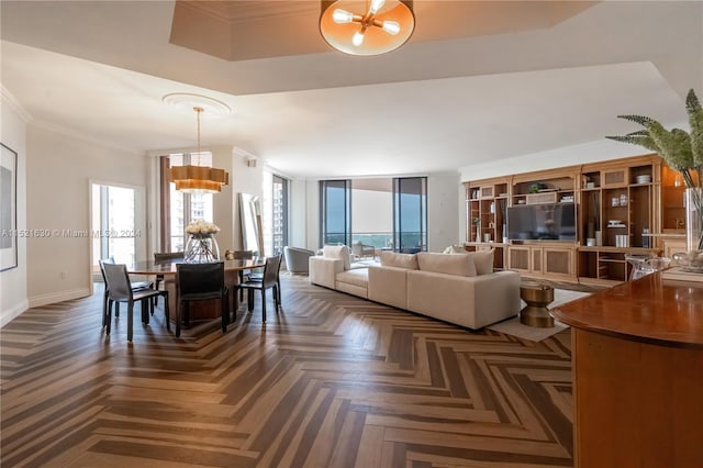 living room featuring a wealth of natural light, dark parquet flooring, and crown molding