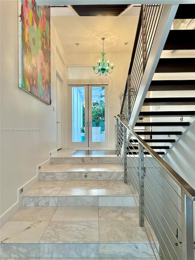 stairs with light tile floors, a chandelier, and french doors