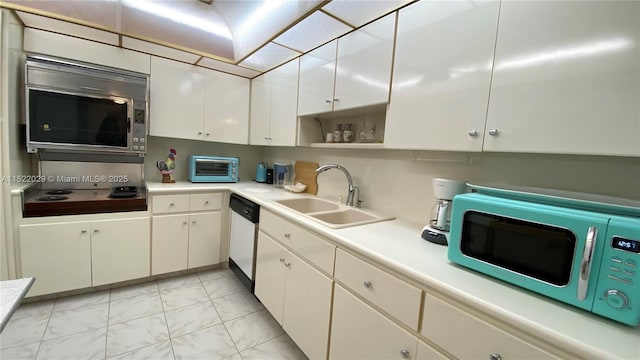 kitchen with cooktop, stainless steel dishwasher, white cabinets, and sink