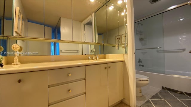 full bathroom featuring tile patterned floors, bath / shower combo with glass door, toilet, and vanity