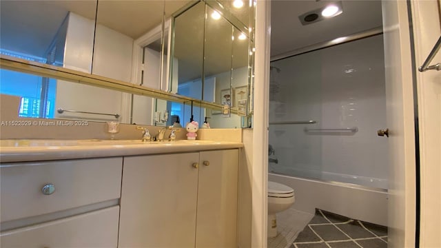 full bathroom with tile patterned floors, bath / shower combo with glass door, toilet, and vanity