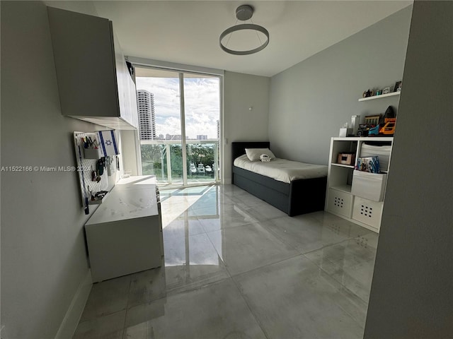 bedroom with expansive windows and light tile floors