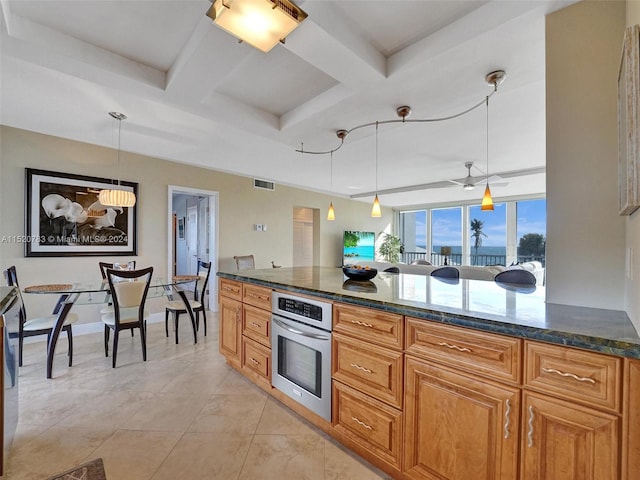 kitchen with light tile patterned flooring, hanging light fixtures, oven, dark stone countertops, and coffered ceiling