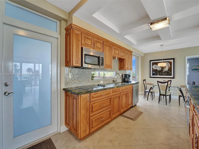 kitchen with tasteful backsplash, light tile patterned floors, appliances with stainless steel finishes, pendant lighting, and sink