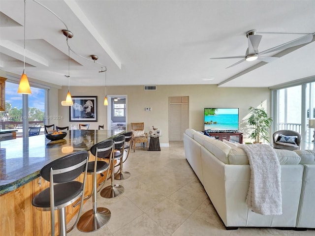 tiled living room with a healthy amount of sunlight and ceiling fan