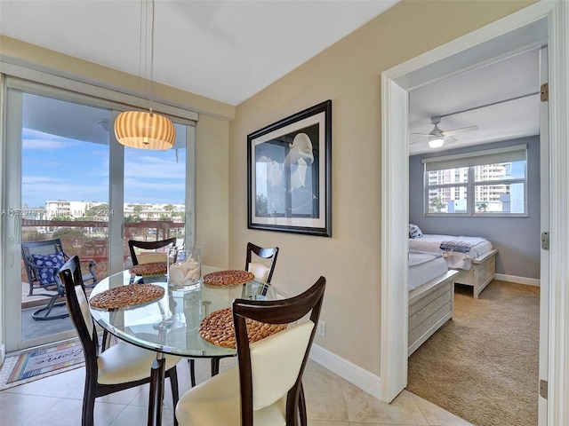 tiled dining space featuring ceiling fan