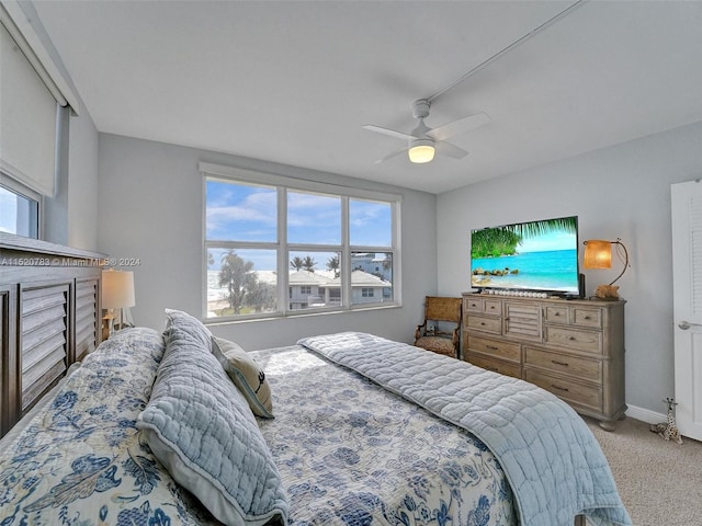 bedroom with light carpet, multiple windows, and ceiling fan