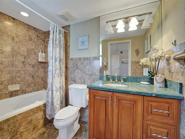 full bathroom with shower / bath combination with curtain, toilet, vanity, tile walls, and tile patterned floors