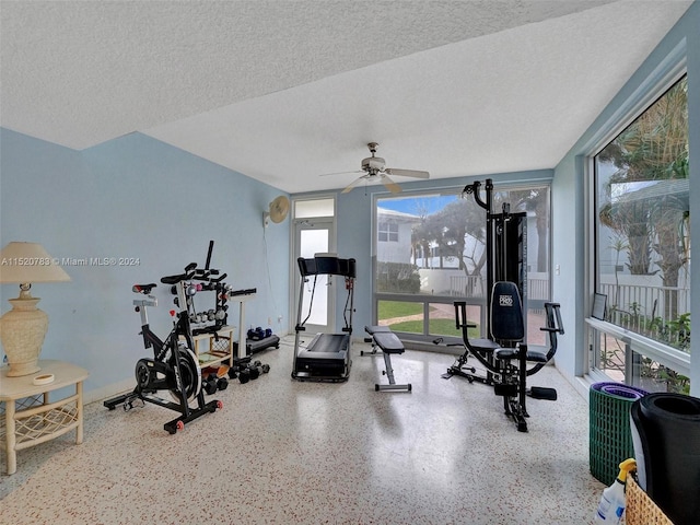 exercise room with a textured ceiling and ceiling fan