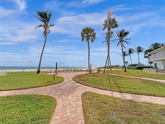 view of home's community with a water view and a lawn