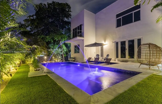 pool featuring french doors, a patio, and a lawn