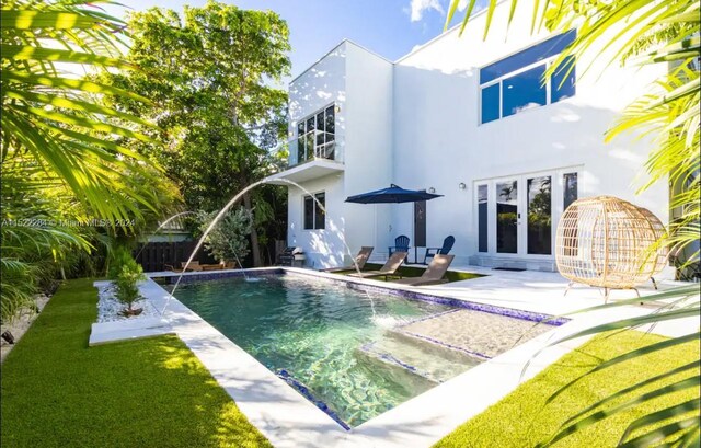 exterior space featuring an outdoor pool, a lawn, french doors, a patio area, and stucco siding