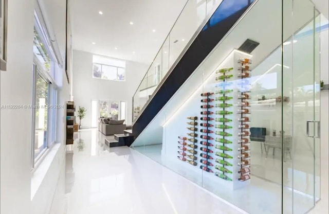 wine area with tile patterned floors and a towering ceiling