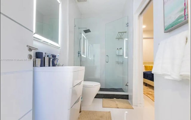 bathroom with a shower with shower door, toilet, and tile patterned floors