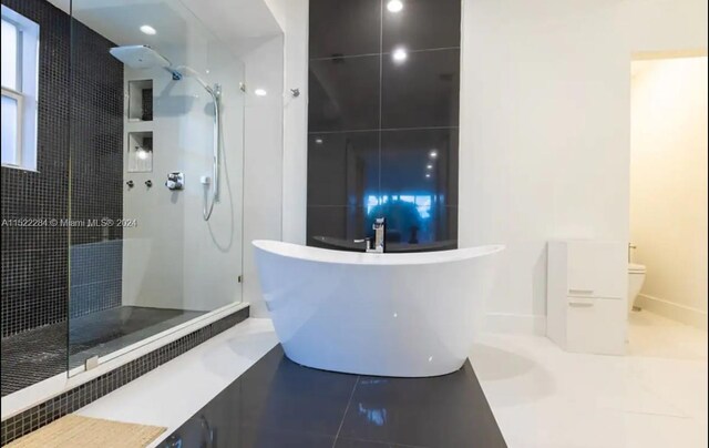 full bath with tile patterned flooring, a freestanding tub, toilet, and walk in shower