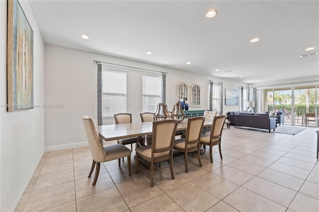 tiled dining space with a textured ceiling