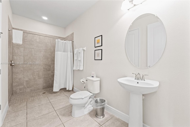 bathroom featuring tile patterned flooring, sink, curtained shower, and toilet