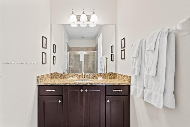 bathroom featuring vanity and a shower with door