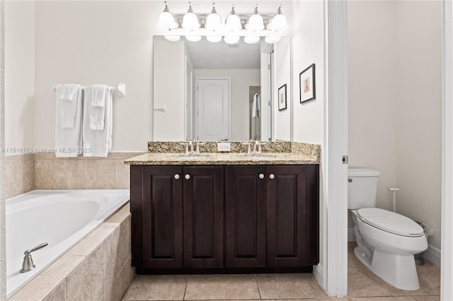 bathroom with a relaxing tiled tub, vanity, tile patterned floors, and toilet